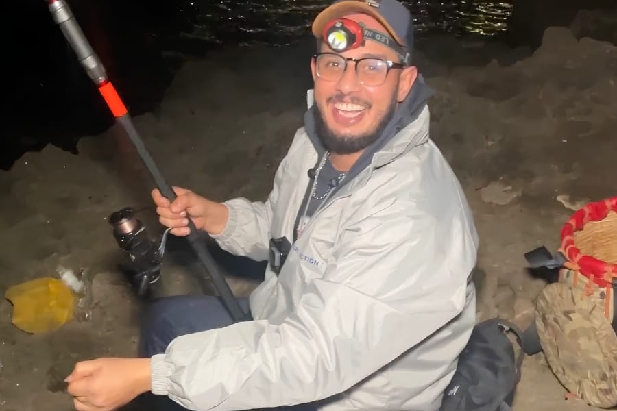 Pêche nocturne au surfcasting — lampe frontale sur la plage